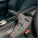 A close-up of a car's automatic gear shift handbrake cover, featuring a gray fabric sleeve with red purple and blue stripes. The brand name 'CONDOR' is visible on a small black label sewn onto the sleeve.